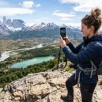 Viajero fotografiando un paisaje con su celular